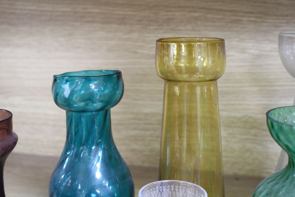 A collection of assorted coloured glassware including hyacinth vases, tallest 21cm